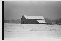 Snow-covered barn in a snowy landscape